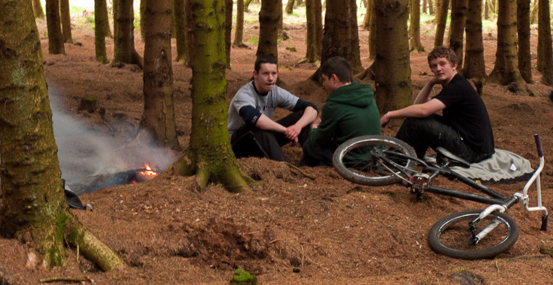 Mountain bikers relaxing by a fire they have lit in Great Meadow plantation. Mountain bikers relaxing by a fire they have lit in Great Meadow plantation.