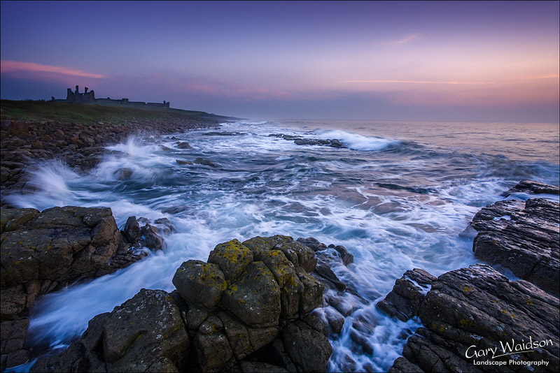 Dunstanburgh castle at sunrise. Landscape photography by Gary Waidson.